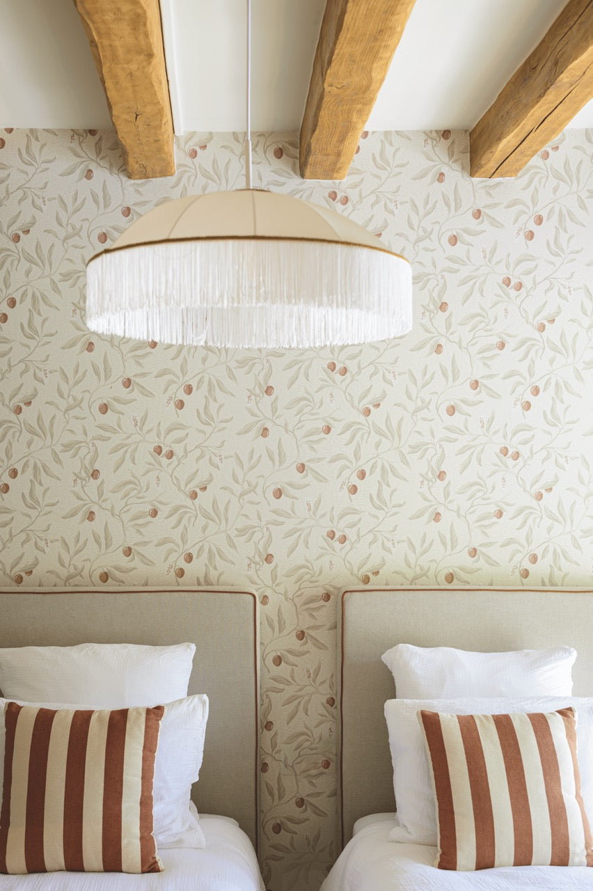 Tête de lit en tissu dans une petite chambre élégante avec coussins rayés et papier peint